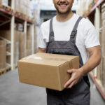 close up smiley man carrying box